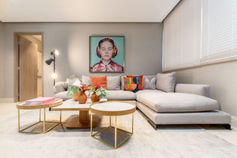 Image of living area with couch, table and chairs and paintings at Deluxe