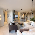 Image of the living area with a couch and chair in this condo for sale in Next in Coco del Mar