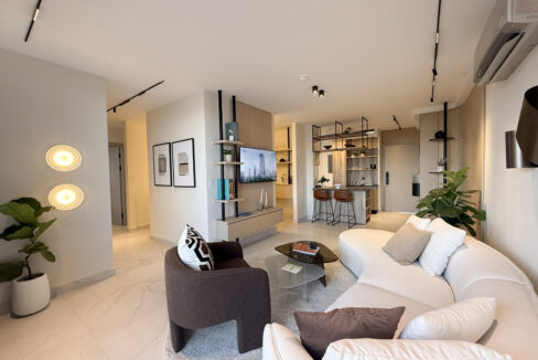 Image of the living area with a couch and chair in this condo for sale in Next in Coco del Mar