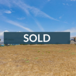 Open grassy lot under a blue sky with nearby houses and palm trees, overlaid with a Panama Equity SOLD banner.
