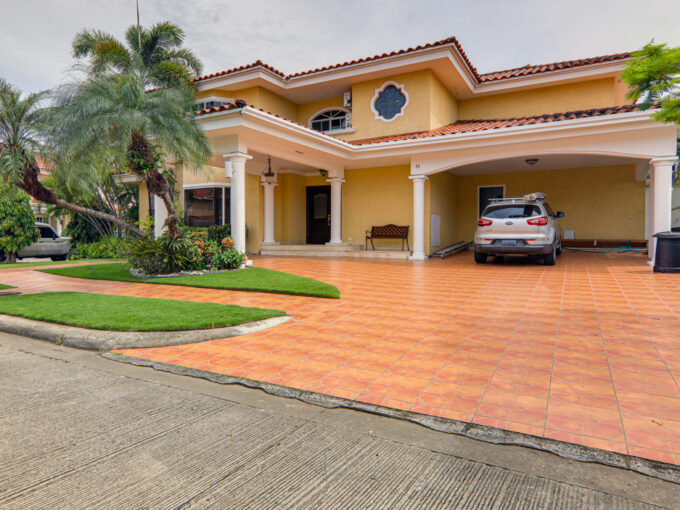 Image of the outside of the house at Palmeras del Este Costa del Este Panama showing palm trees, and the covered parking space