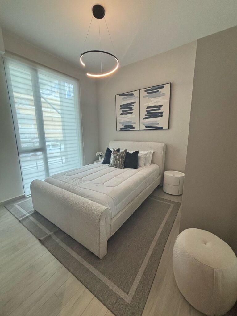 Image of the bedroom with a bed and floor to ceiling windows at Alexa Tower