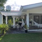 Image of the outside of this Rio Mar home with a hammock, table and chairs