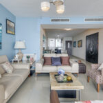 Image of the living room in this condo in San Francisco Bay with a coffee table, two couches and two chairs