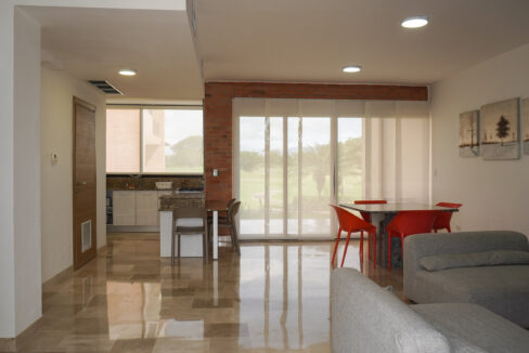 Image of the living area with television, table and two chairs in this condo in Vista Mar