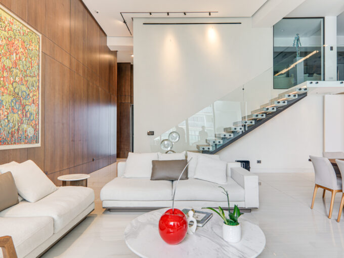 Image of living area with couch, table and stairwell in this condo in Oasis on the Bay