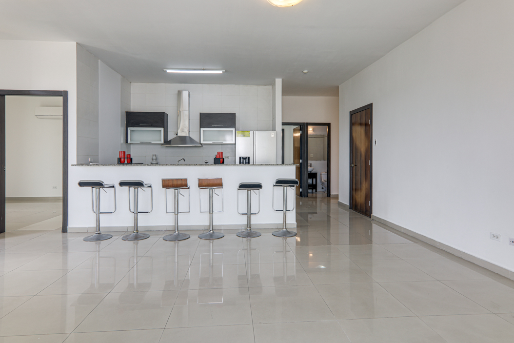 Image of living space with views of the kitchen with countertop and stools in this condo in Quadrat in San Francisco