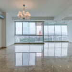 Image of living area with floor to ceiling windows and lampshade in this condo in Titanium in Costa del Este