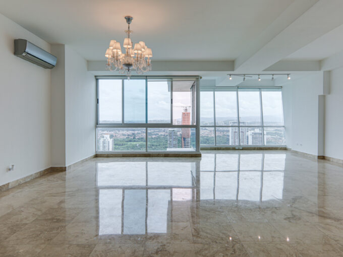Image of living area with floor to ceiling windows and lampshade in this condo in Titanium in Costa del Este