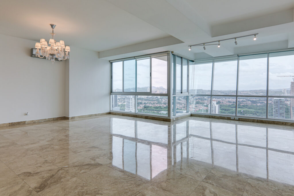 Image of living area with floor to ceiling windows and lampshade in this condo in Titanium in Costa del Este