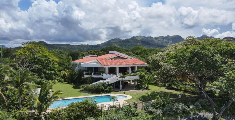 Image of house with trees ,pool and mountain in Playa Malibu Gorgona