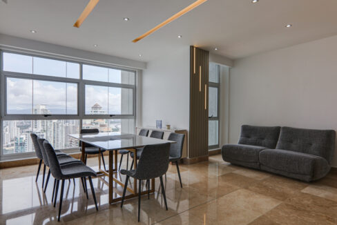 Image of dining area with table, chairs, and couch in this condo in Q Tower