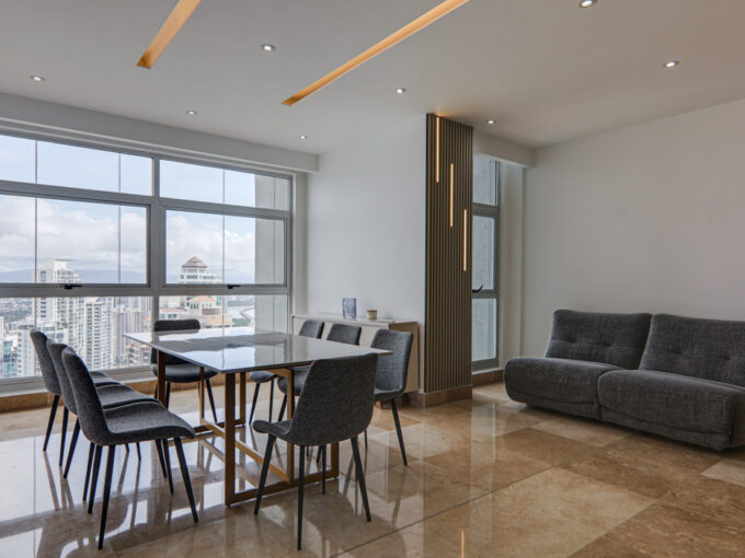 Image of dining area with table, chairs, and couch in this condo in Q Tower