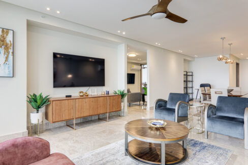 Image of living area with television, table, two chairs and plant in this condo in Costanera in Bella Vista