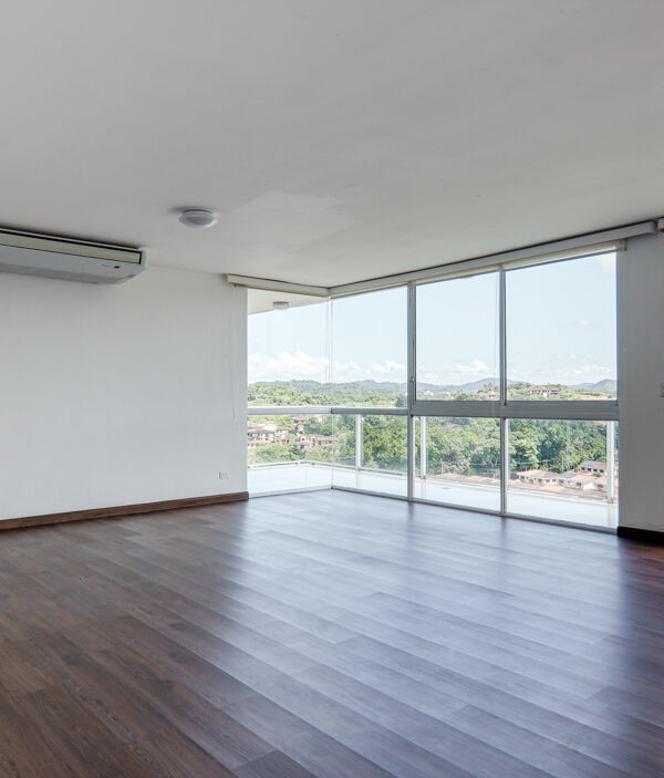 Image of living room with large windows and AC in this penthouse in Pine Hill