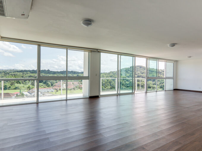 Image of living area with large windows in this penthouse in Pine Hill