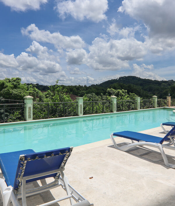 Image of swimming pool with deck chairs in Pine Hill