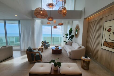 Image of living space with couch, two chairs, and balcony in this loft in Ocean Waves, Gorgona