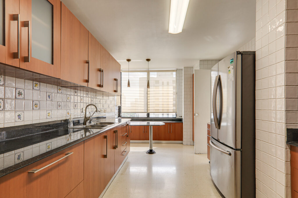 Image of kitchen with cabinetry and refrigerator in this condo in La Ronda