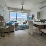 Image of living area with couch, table and chairs in this condo in Ocean Waves