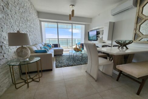 Image of living area with couch, table and chairs in this condo in Ocean Waves