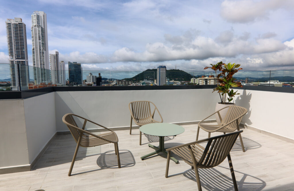 Image of rooftop terrace with table and chairs in this condo in Alexa
