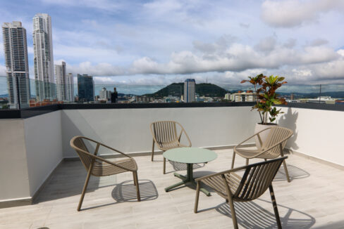 Image of rooftop terrace with table and chairs in this condo in Alexa