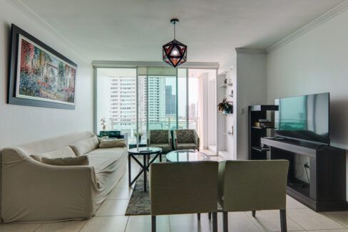 Image of the living room with couch and table in this condo in Emporium Tower