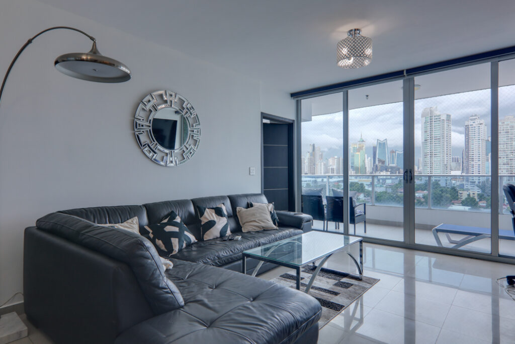 Image of the living area with couch, table, and baclony in this Remodeled Condo for Sale