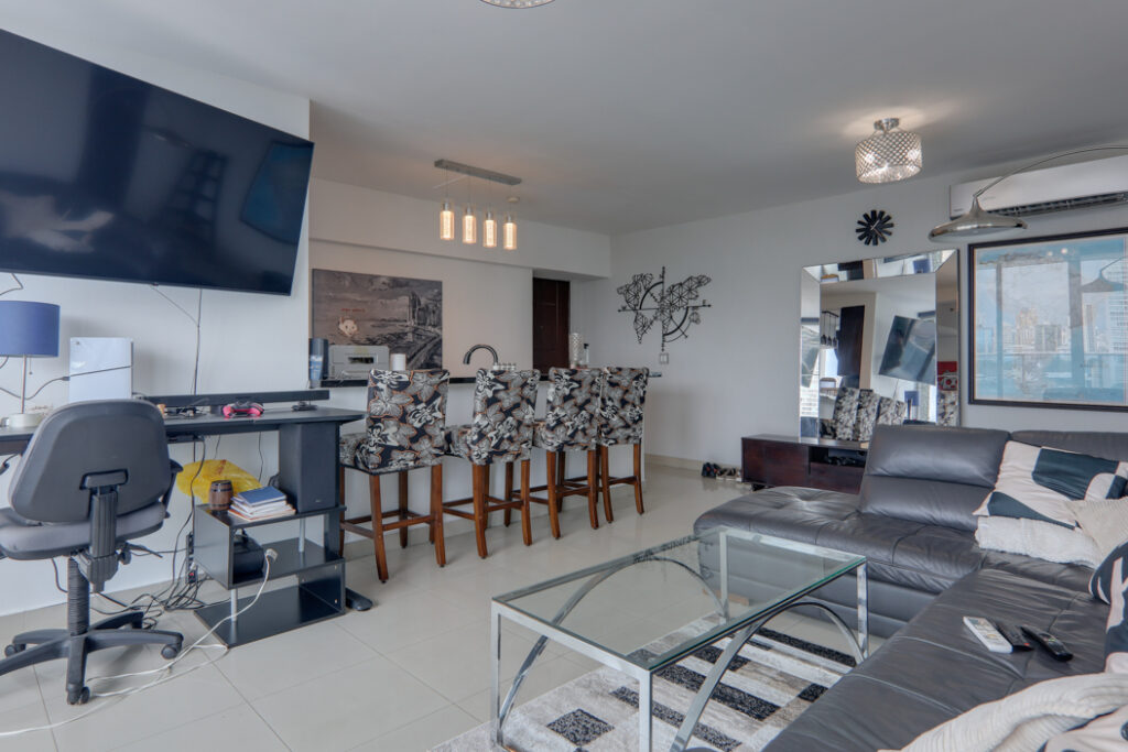 Image of the living area with couch, television, and a desk and computer in this Remodeled Condo for Sale