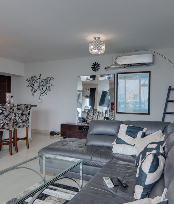 Image of living room with couch and partial view of kitchen in this Remodeled Condo for Sale