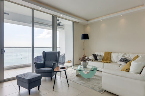 Image of living area with table, couches and chairs in this condo for sale in Rivage Tower