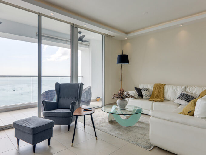 Image of living area with table, couches and chairs in this condo for sale in Rivage Tower