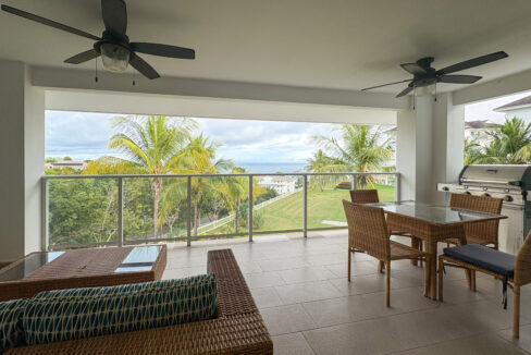 Image of terrace with green views, couch, table and chairs in this condo for sale in Quarry Heights