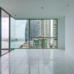 Image of living room with windows with views of th city and skyline in this condo for sale in Pacific Point