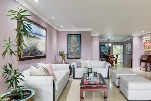 Image of the living room with table with couch in this condo for sale in Las Brisas