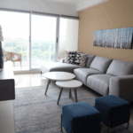 Image of living area with couch, tables and balcony in this furnished condo for sale in Residences del Sol