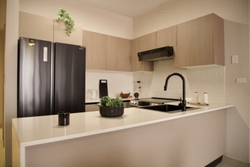 Image of kitchen with refrigerator and countertop in this Model F Two Bedroom Condo in Aura Obarrio