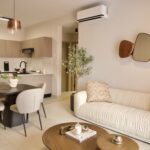 Image of living and dining space with couch, table and chairs in this condo for sale in Aura