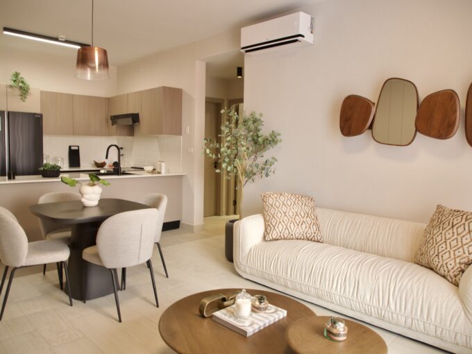 Image of living and dining space with couch, table and chairs in this Model F Two Bedroom Condo in Aura Obarrio