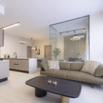 Image of living area with couch and table in this condo for sale in Aura