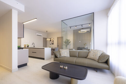 Image of living area with couch and table in this condo for sale in Aura