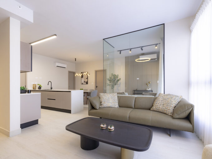 Image of living area with couch and table in this condo for sale in Aura