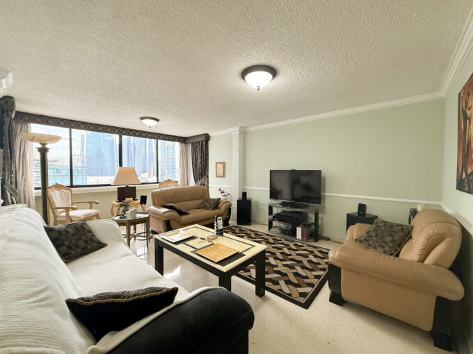 Image of living room with television, couch and table in this condo for sale in Monaco