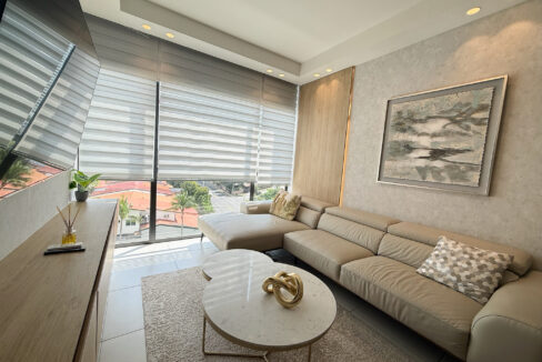 Image of living space with couch, table and window in this condo for sale in Coco Place