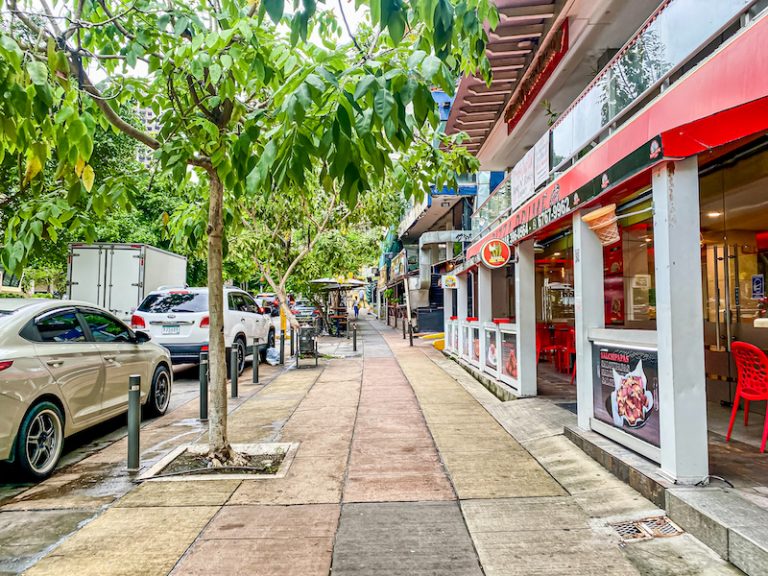 Vibrant tree-lined street with shops and sidewalk cafes in El Cangrejo Panama City real estate services by Panama Equity Real Estate