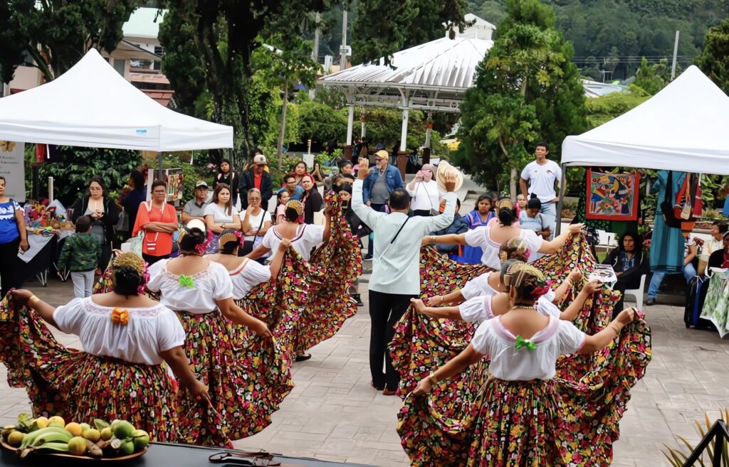 Traditional Panamanian folklore dancers performing outdoors in a town square showcasing Panama property management for foreign owners in Boquete by Panama Equity Real Estate