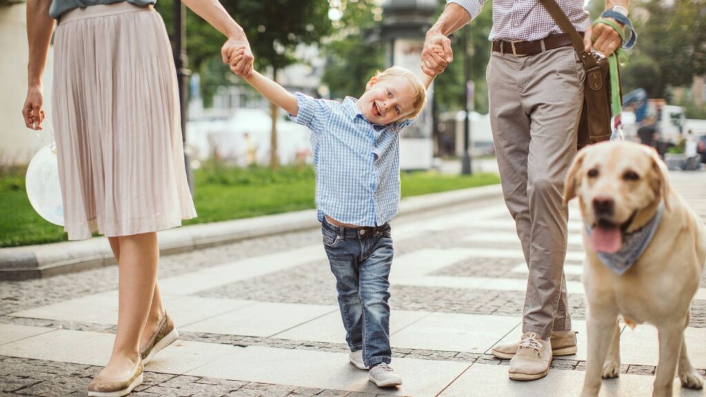 Happy family with a young boy and a dog walking together reflecting permanent residency in Panama real estate services in Panamá by Panama Equity Real Estate
