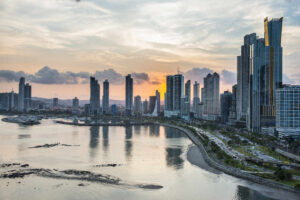 Waterfront coastal bay with modern skyscraper skyline at sunset highlighting the best time to visit Panama real estate services in Panamá by Panama Equity Real Estate