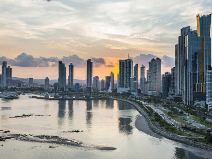Waterfront coastal bay with modern skyscraper skyline at sunset highlighting the best time to visit Panama real estate services in Panamá by Panama Equity Real Estate
